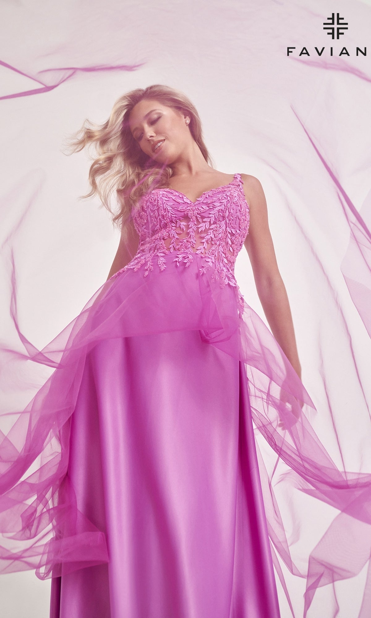 A woman in the Faviana Sheer-Bodice Long Tulle Prom Dress 11055 stands under soft lighting, with the Faviana logo in the top right corner.